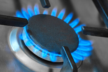 Closeup of the blue flames from a domestic gas stove in a kitchen. Gas stove with burning flames of...