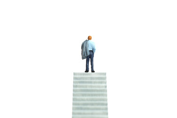 Obraz premium Miniature tiny people toy figure photography. Business concept illustration. A depressed businessman standing at the end of stair. Isolated on white background