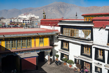 LHASA, TIBET, CHINA: elevated view of courtyard of Jokhang temple, Barkhor square and Potala Palace, sunny dry winter afternnoon