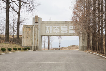 PANUMJUOM, NORTH KOREA: concrete gate with anti-tank blocks and korean scriptures (translation: Independent Unification), near Tongilgak (Unification Building) and Peace Museum, JSA