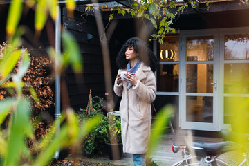 Portrait of attractive young european woman drinking coffee outside home
