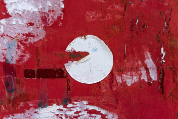 Torn Ripped Old White Round Circle Sticker on the Dirty Red Urban Street Wall Surface. Grunge Rough Dirty Background. Distress Texture for Mixed Media Collage. 
