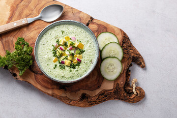 Green cucumber gazpacho cold cream soup styled and decorated in rustic bowl