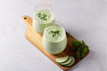 Green cucumber gazpacho cold cream soup styled and decorated in rustic bowl