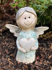 Grab schmuck, kleiner Engel mit Herz in der Natur auf dem Friedhof