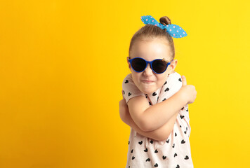 Cute upset little girl standing on yellow background. Space for text
