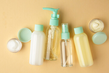 Travel cosmetic bottles on beige background. Minimalist bodycare beauty products for vacation or journey. Top view. Copyspace.