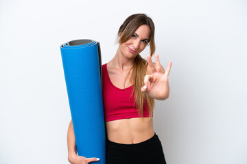 Young sport woman going to yoga classes while holding a mat isolated on white background happy and counting three with fingers