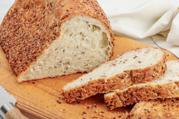 Fresh bread with with various seeds. Home baking gluten free concept, hobby. Wooden cutting board