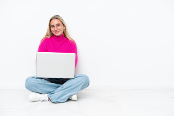 Young caucasian woman with laptop sitting on the floor keeping the arms crossed in frontal position