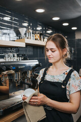 Fototapeta na wymiar A barista in a cozy atmosphere of a cafe brews and prepares fresh fragrant coffee