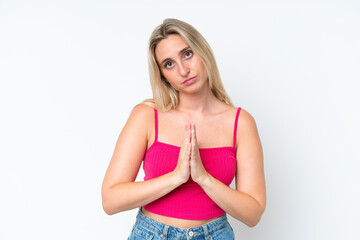 Young caucasian woman isolated on white background keeps palm together. Person asks for something