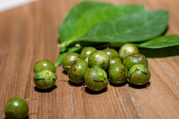 Henna ( Lawsonia inermis) leaves, fruit on wooden background, hair dye medicinal herbs