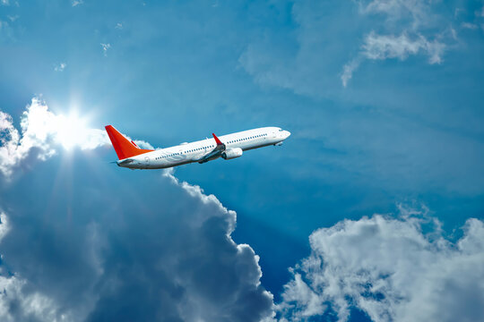 Airplane Flying In The Sky. Airplane In The Blue Sky With Clouds. Close Up. High Flying Passenger Plane. Jet Plane Flying In Sky With Sunbeam. Side View 