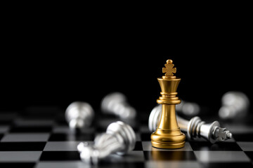 Golden king chess with pawns on chess board with black background. Leader and success concept.