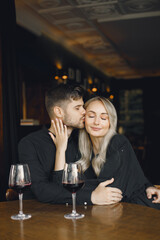 Couple hugging and have wine in cafe