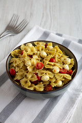 Homemade Pesto Pasta with Tomatoes ans Mozzarella in a Bowl, side view.