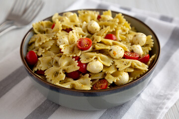 Homemade Pesto Pasta with Tomatoes ans Mozzarella in a Bowl, low angle view.