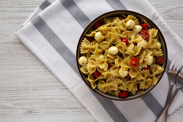 Homemade Pesto Pasta with Tomatoes and Mozzarella in a Bowl, top view. Copy space.