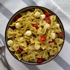 Homemade Pesto Pasta with Tomatoes and Mozzarella in a Bowl, top view. Flat lay, overhead, from above.