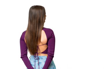 Young beautiful woman over isolated chroma key background in back position and looking back