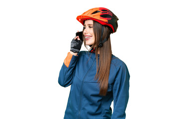 Young cyclist woman over isolated chroma key background keeping a conversation with the mobile phone