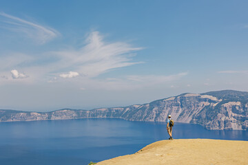 Man standing with a view to a scenic lake, summer travel, Crater Lake, Oregon, USA © Diana Vyshniakova