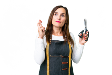 Seamstress woman over isolated chroma key background with fingers crossing and wishing the best
