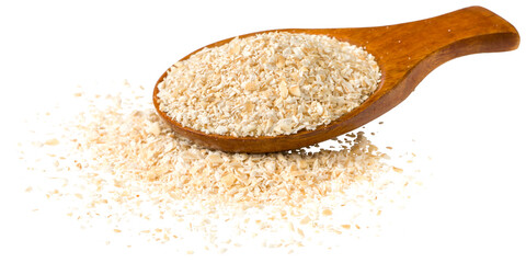 Raw oat bran in the wooden spoon, isolated on white background.