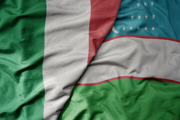 big waving national colorful flag of italy and national flag of uzbekistan .