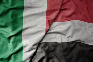 big waving national colorful flag of italy and national flag of yemen .