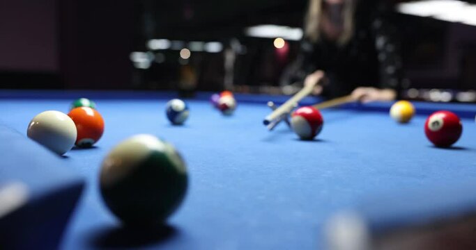 Hands of woman beautifully chase billiard balls on spacious table in billiard room. Billiard game concept