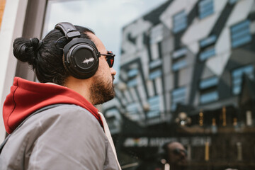  A handsome guy with big headphones and stylish casual clothes on a city street