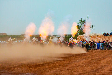 Fototapeta premium Equestrians participating in a traditional fancy dress event named Tbourida in Arabic dressed in a traditional Moroccan outfit and accessories of the knights