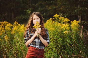 preteen 11 years old kid girl walking on summer countryside road, enjoying vacations outdoor