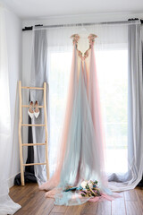 Wedding dress hanging on a hanger in the room