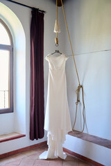 Wedding dress hanging on a hanger in the room