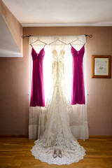 Wedding dress hanging on a hanger in the room