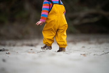baby on the beach in yellow overalls
