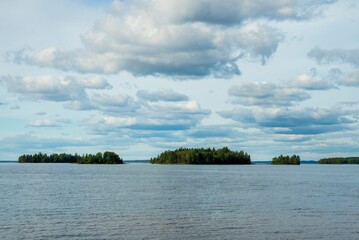 Wild lake in the forest, blue sky and white clouds