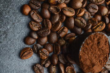 beans and ground coffee lie on a gray table