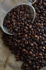 Fototapeta premium spilled coffee beans from the cup on the table