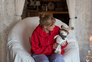 A beautiful girl in a red bike shows her soft toys made with her own hands