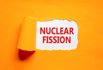 Nuclear fission symbol. Concept words Nuclear fission on beautiful white paper. Beautiful orange...