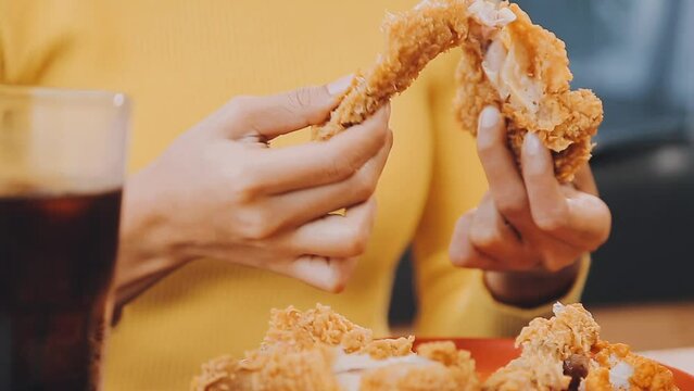 people are eating food, fried chicken together.