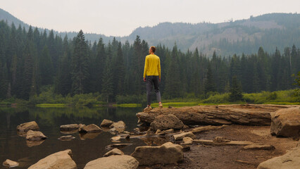 Man hiker standing on a log at Mirror Lake in Oregon, USA