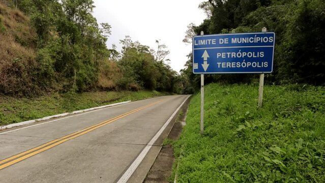 Estrada com sinaliza&ccedil;&atilde;o de transito de  limites de municipios entre Teres&oacute;polis e Petropolis