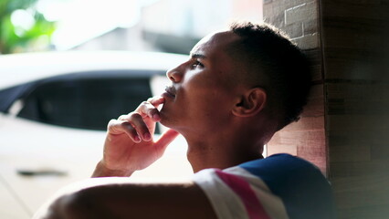 One contemplative young black Brazilian man thinking about life with hand in chin. Thoughtful expression of a person with African American descent in deep mental reflection-SD 48
