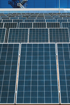 vClose-up vertical image of a lot of industrial solar panels for the production of electricity.