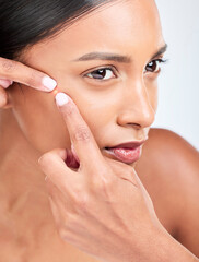 Face, woman and squeeze acne in studio of glowing spot, breakout or check dermatology on white...